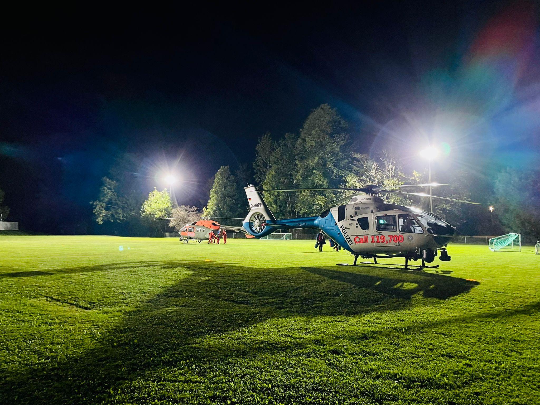 Helikopter bei der Zwischenlandung auf einem beleuchteten Fußballplatz